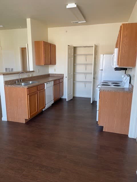A kitchen with wooden cabinets and a white fridge.
