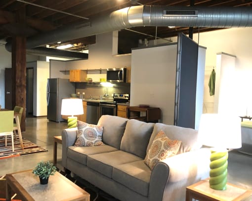 a living room with a couch and a kitchen in the background