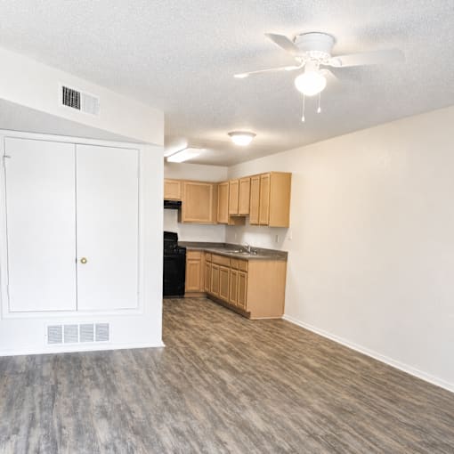 A kitchen with a white door and a black dishwasher.