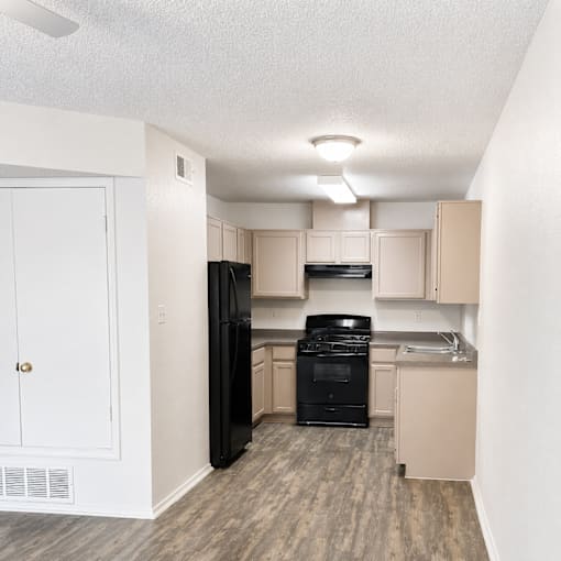 A kitchen with black appliances and white walls.
