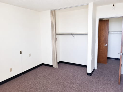 A room with a brown carpet and a brown door.