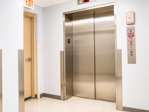 A silver elevator with a door open to the right.