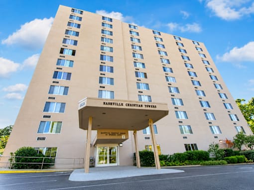 A large building with a beige facade and a sign that reads "Haslev Christian Towers".