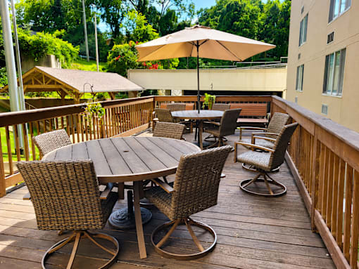 A patio with a table and chairs and an umbrella.