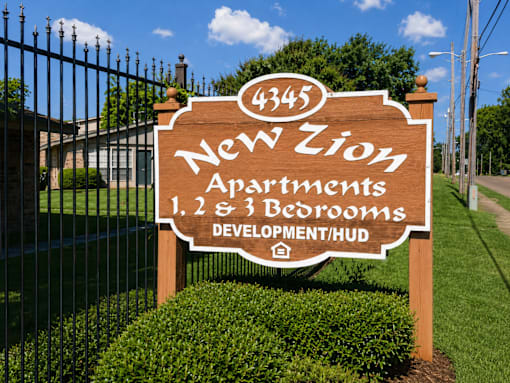 A sign for New Zion Apartments with 1, 2, and 3 bedrooms.
