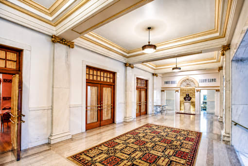 A large, ornate hallway with a patterned carpet and a chandelier.