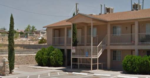 an apartment building with a balcony and a parking lot