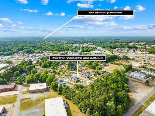 An aerial view of a town with a sign indicating the location of Orchard Point Elementary School.