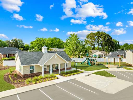 A sunny day at a residential area with a playground and a small building.