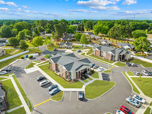 A parking lot with cars and a building in the background.