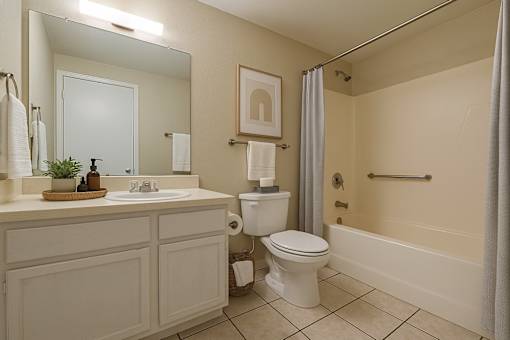 A bathroom with a toilet, sink, and bathtub.