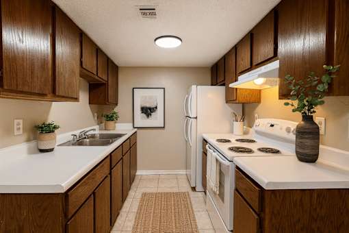 A kitchen with brown cabinets and white appliances.