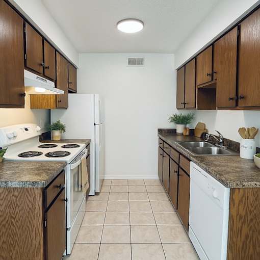 A kitchen with white appliances and wooden cabinets.