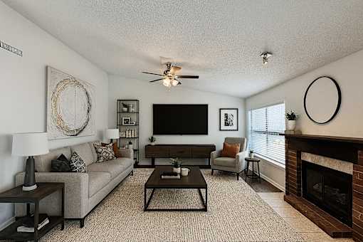 A living room with a fireplace and a flat screen TV.