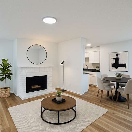 A modern living room with a fireplace and a dining area.