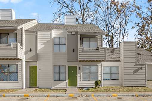 A modern two story house with a green door and a balcony. at Osage Creek, Rogers, Arkansas