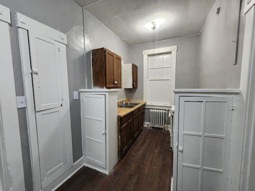 A kitchen with white cabinets and a wooden counter.