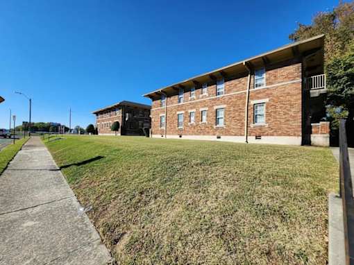 A brick building with a green lawn in front.