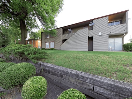 A modern house with a grey exterior and a wooden fence in front.