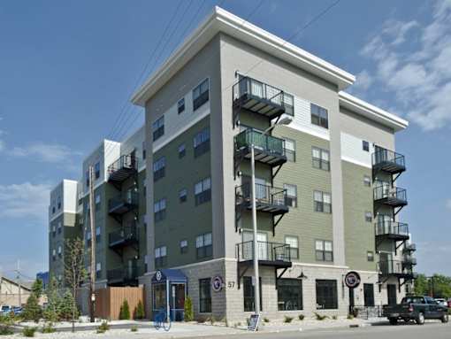 A large apartment building with a green and beige exterior.