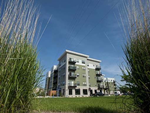 A modern apartment building with a grassy area in front.