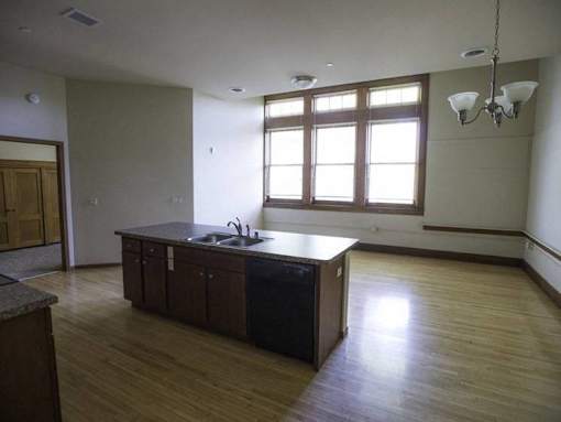 A kitchen with wooden floors and a large island.