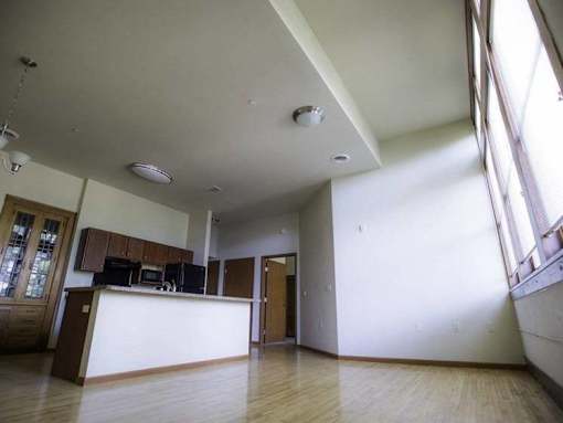 A large open room with a bar and wooden floors.