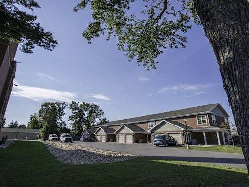 A large house with a driveway and a car parked in front.