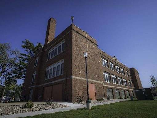 A large brick building with a brown door and windows.