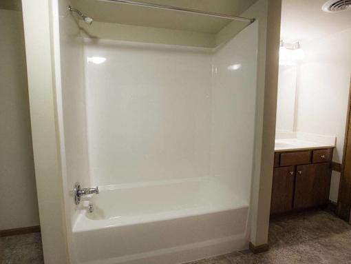 A white bathtub with a shower head and a faucet.