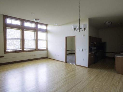 A room with wooden floors and a chandelier.