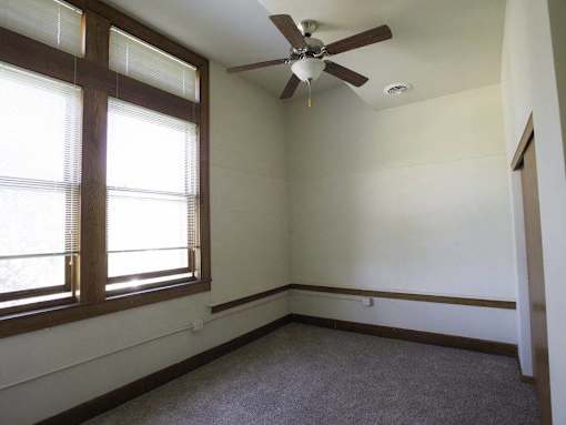 A room with a ceiling fan and a window.