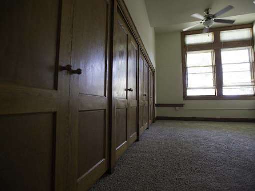 A room with wooden doors and a ceiling fan.