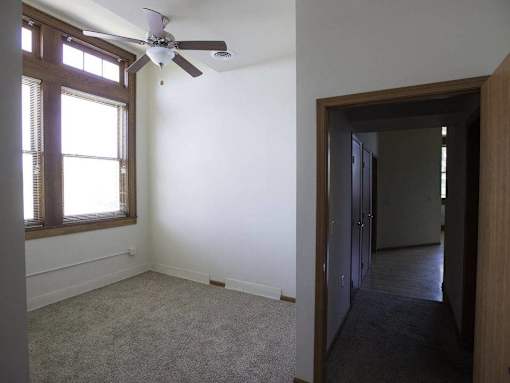 A room with a ceiling fan and a window.