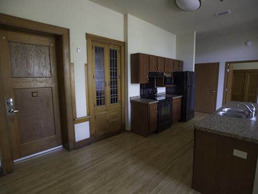 A kitchen with wooden floors and cabinets.