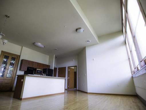 A large, empty room with wooden floors and white walls.
