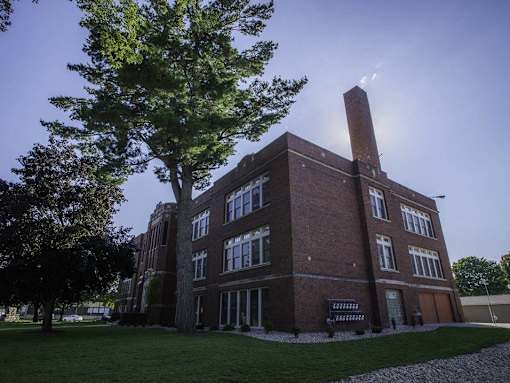 A large brick building with a tree in front of it.