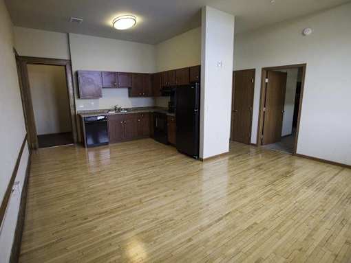 A kitchen with wooden floors and a refrigerator.