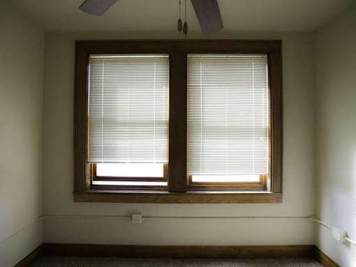 A room with a window covered in blinds.