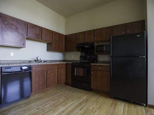 A kitchen with black appliances and wooden cabinets.