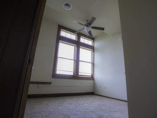 A room with a ceiling fan and a window.