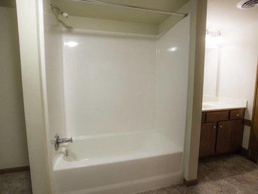 A white bathtub with a silver faucet is in a bathroom.
