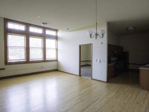 A room with wooden floors and a chandelier.