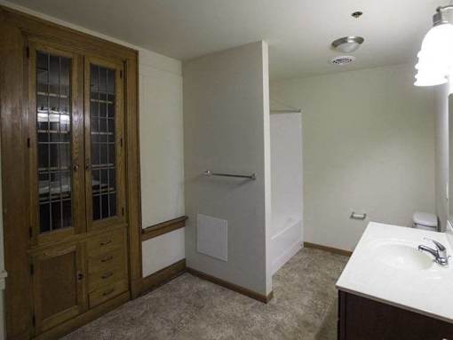 A bathroom with a sink, mirror, and a shower stall.