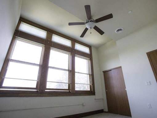 A room with a ceiling fan and a window.