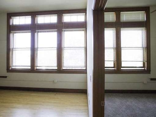 A room with a large window and a carpet on the floor.