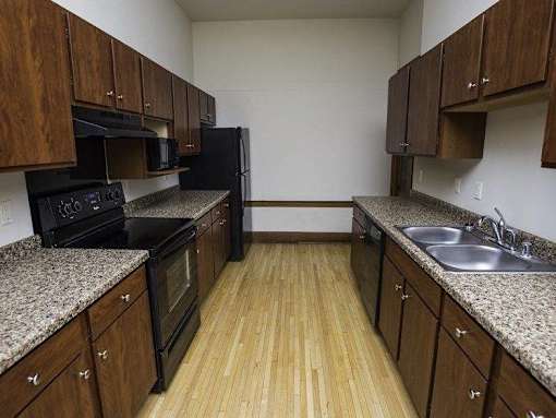 A kitchen with wooden cabinets and black appliances.