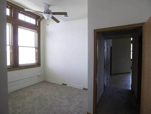 A room with a ceiling fan and a window.
