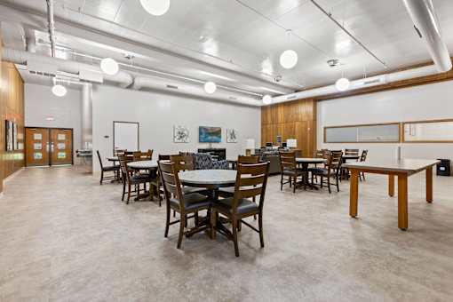 A room with tables and chairs and a white ceiling.