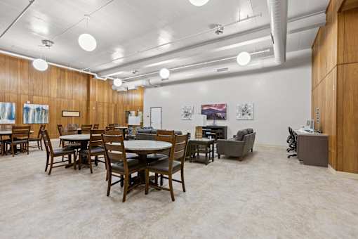 A room with tables and chairs and a white ceiling.